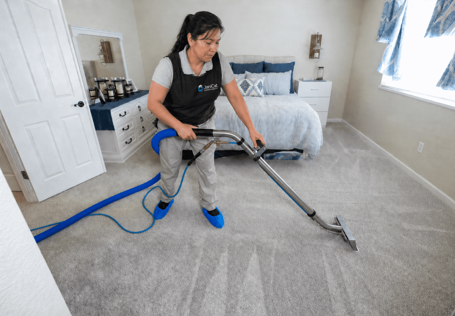 Janicat team member deep-cleaning a bedroom carpet in Seattle