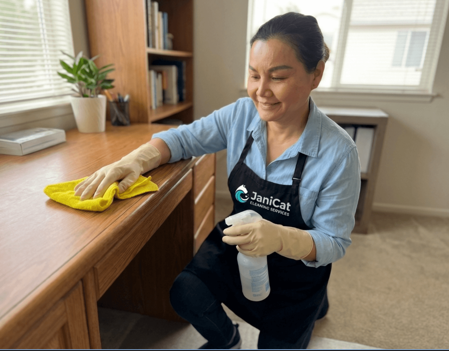 Janicat team member cleaning a residential desk